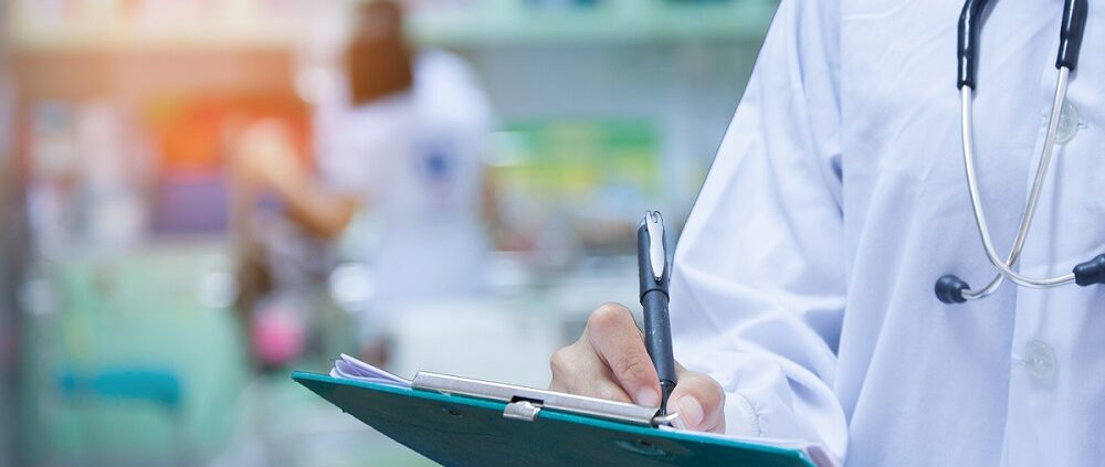 Doctor writing a medical prescription in hospital